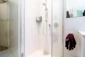 uma casa de banho com um chuveiro e uma porta de vidro em SPACIOUS for BIG GROUPS OKTOBERFEST / BAUMA em Munique