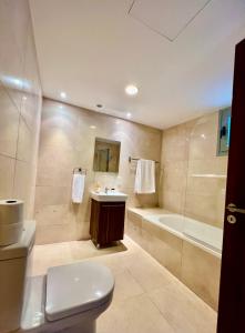 a bathroom with a toilet and a tub and a sink at Aphrodite Plaza in Larnaka