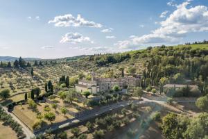 una vista aerea di una villa in una valle alberata di Pieve Aldina Relais & Châteaux a Radda in Chianti