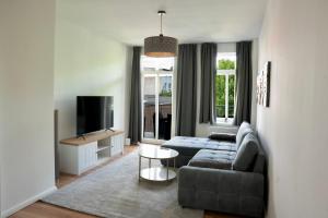 a living room with a couch and a tv at Wunderschöne Ferienwohnung inmitten der Altstadt in Schwerin