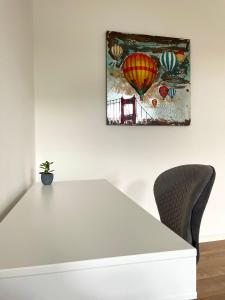 a white table with a potted plant and a picture of balloons at Wunderschöne Ferienwohnung inmitten der Altstadt in Schwerin