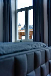 Bett mit Fenster und Blick auf ein Gebäude in der Unterkunft Wunderschöne Ferienwohnung inmitten der Altstadt in Schwerin