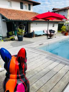 a colorful cat statue sitting on a deck next to a swimming pool at MAISON GANTTIPIENEA in Ahetze