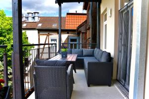 a patio with a couch and chairs on a balcony at Wunderschöne Ferienwohnung inmitten der Altstadt in Schwerin
