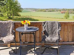 een terrastafel met 2 stoelen en een vaas met bloemen bij 6 person holiday home in Sl inge in Slöinge