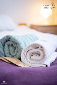 a blue and white towel on a bed at Zajazd Leśny Zwierzyniec in Zwierzyniec