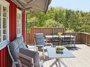 une terrasse couverte avec une table et des chaises. dans l'établissement 6 person holiday home in Sl inge, à Slöinge