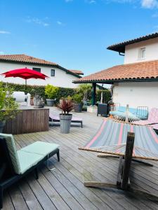 una terraza de madera con hamaca y una casa en MAISON GANTTIPIENEA, en Ahetze