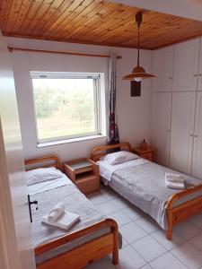 two beds in a room with a window at Alykesbeachhouse in Drosia
