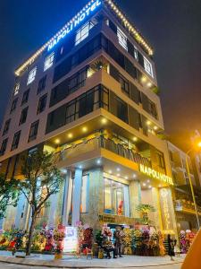 a large building with people standing in front of it at Napoli Hotel in An Khê