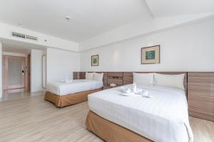 2 łóżka w pokoju hotelowym z białymi ścianami w obiekcie Crown Regency Hotel & Towers w Cebu