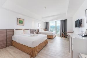 宿务Crown Regency Hotel & Towers的一间有两张床和厨房的酒店房间