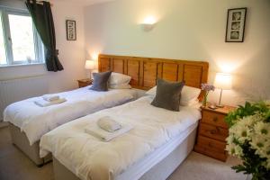 two beds sitting next to each other in a bedroom at Sladen Lodge in Hathersage