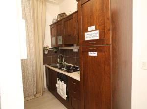 La cuisine est équipée de placards en bois et d'un four avec plaques de cuisson. dans l'établissement Maison Floria Locazione Turistica, à Pescara