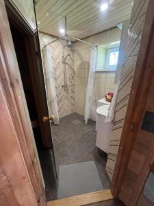 a small bathroom with a shower and a sink at Vahtra allee külalismaja 