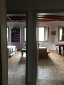 a room with a bed and a living room with a table at Due Delfini Apartment in Venice
