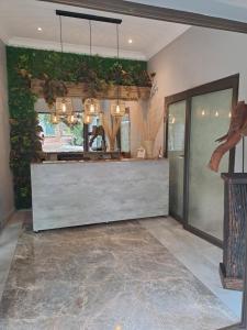 a lobby with a reception counter with plants on the wall at Shangrila-innibos Country Lodge in Hartbeespoort