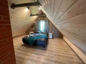 una camera con un letto in una stanza con pareti in legno di Vahtra allee külalismaja 
