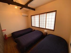 Dos camas en una habitación con ventana. en 継TSUNAGU 玉鬘Tamakazura, en Kioto