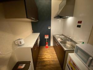 Una pequeña cocina con fregadero y estufa. en 継TSUNAGU 玉鬘Tamakazura, en Kioto