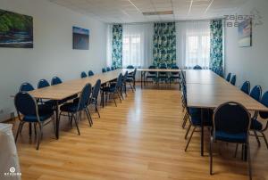 una gran sala de conferencias con mesas y sillas de madera. en Zajazd Leśny Zwierzyniec, en Zwierzyniec