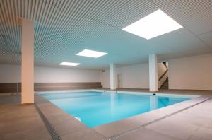 レンツァーハイデにあるApartment La Riva 105 Lenzerheide with an indoor Poolの天井の建物内の大型スイミングプール