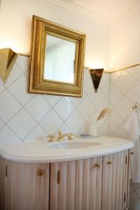 ein Bad mit einem Waschbecken und einem Spiegel in der Unterkunft Kaffeehaus Kranzbach in Krün