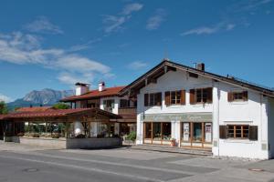 ein weißes Gebäude an der Straßenseite in der Unterkunft Kaffeehaus Kranzbach in Krün