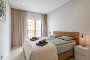 a bedroom with a bed with two towels on it at Apartamento Rocha Mar by Portucasa in Portimão