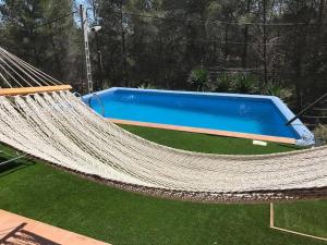 a hammock in front of a swimming pool at Villa con piscina privada in Olivella