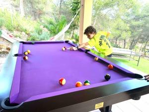 a man playing a game of pool on a pool table at Villa con piscina privada in Olivella