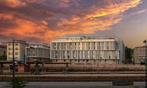 a large white building with a cloudy sky above it at Apparthotel Le Hüb TOULON in Toulon