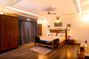 een slaapkamer met een bed en een stoel bij The Chronicles Hotel in Udaipur