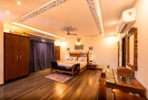 um quarto com uma cama e uma cadeira num quarto em The Chronicles Hotel em Udaipur