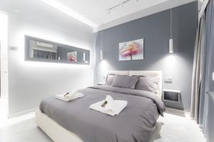 a bedroom with a large bed with two towels on it at Lux seaside apartment by Volos hospitality in Volos