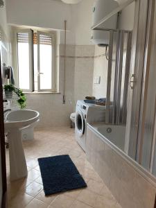 a bathroom with a tub and a washing machine in it at APPARTAMENTO CENTRALE SANTA MARINELLA in Santa Marinella