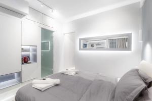 une chambre blanche avec un grand lit et un miroir dans l'établissement Lux seaside apartment by Volos hospitality, à Vólos 13 autres photos