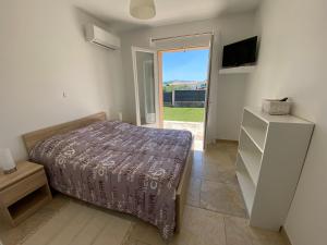 a bedroom with a bed and a tv and a window at Villa Triskyl in Le Muy