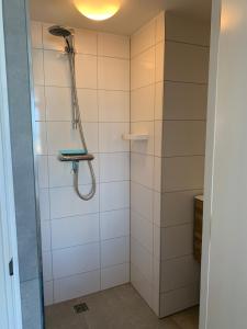 ein Bad mit einer Dusche und weißen Fliesen in der Unterkunft North Sea Spirit in Zandvoort + 50 Fotos