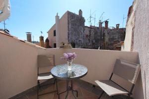 stół i krzesła na balkonie z wazonem kwiatów w obiekcie Apartment Midea w Rovinj