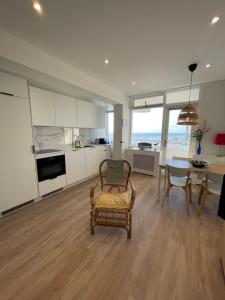 ein Wohnzimmer mit einem Tisch und einem Stuhl sowie eine Küche in der Unterkunft North Sea Spirit in Zandvoort