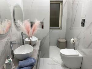 Baño blanco con aseo y lavamanos en House Serapide Puteoli, en Quarto
