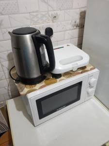 a coffee pot sitting on top of a microwave at Comfy zone in Abu Dhabi