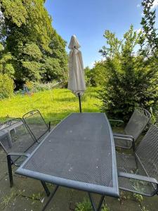 een tafel en stoelen met een parasol in de tuin bij 2 Schlafenzimmer 5 Betten in Duisburg