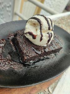 a chocolate cake with ice cream on a black plate at Bella Louise Bar Resto in Busuanga