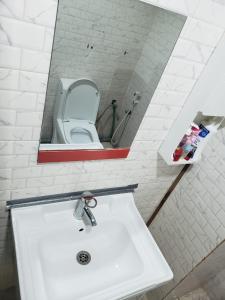 a bathroom with a sink and a mirror and a toilet at Comfy zone in Abu Dhabi