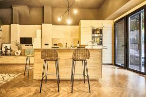 una cocina con 2 taburetes y una barra en Ginger - Exclusivo Loft Urbano en San Vicente del Raspeig