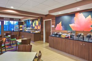 a restaurant with tables and chairs and a counter at Fairfield Inn and Suites Chicago Lombard in Lombard