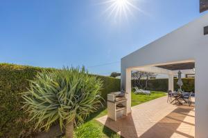 une terrasse avec un barbecue et une plante dans une cour dans l'établissement Villa Botelha, à Sagres