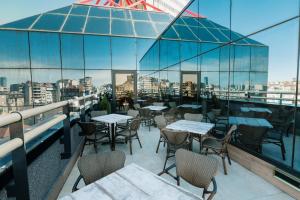Hotel Slavija Lux في بلغراد: مطعم على طاولات وكراسي على شرفة